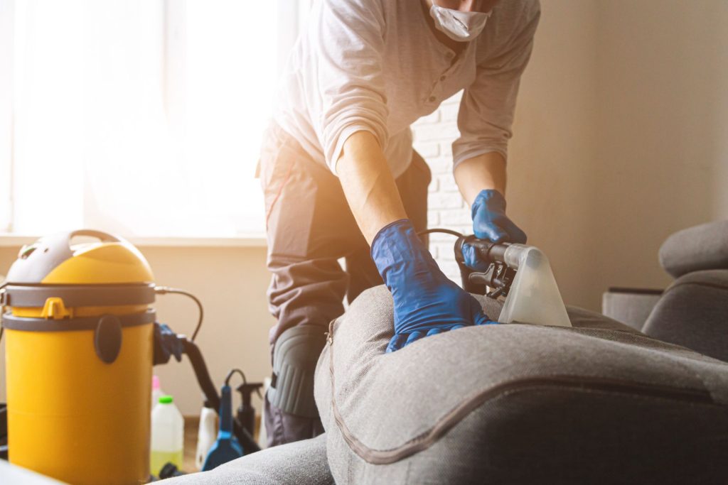 Man vacuuming the sofa